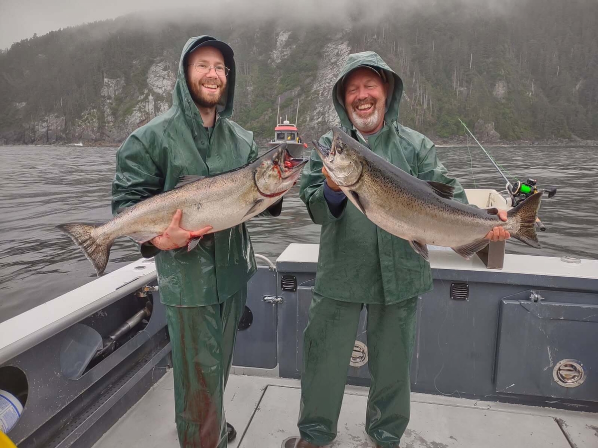 Two smiling fishermen with a double catch of King Salmon in Sitka, Alaska